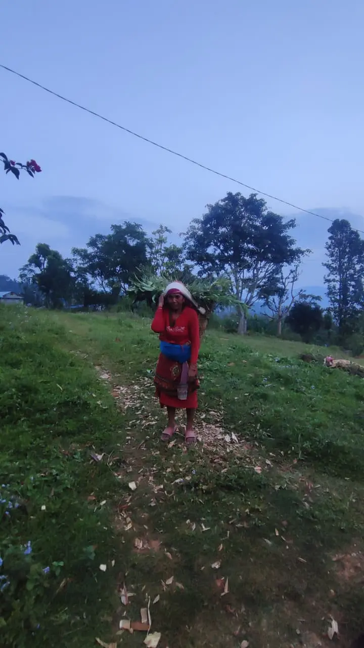 Een vrouw loopt over een landweg in de heuvels van Nepal.