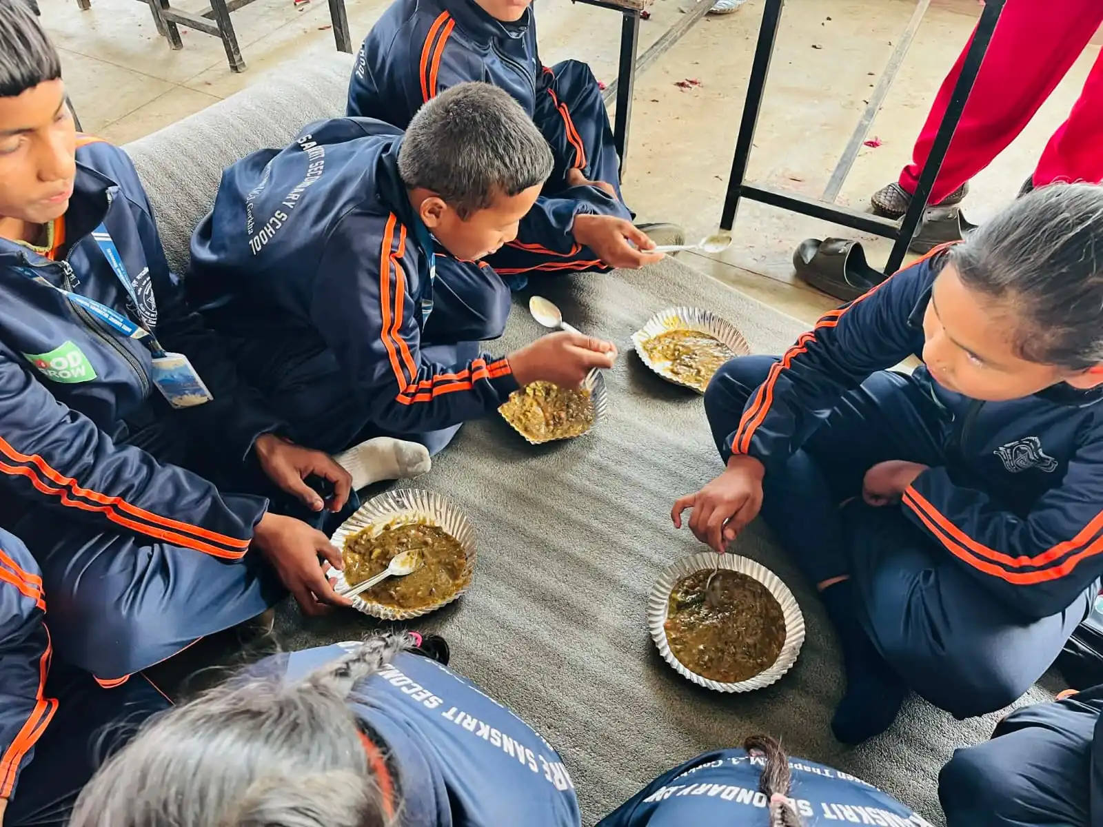 Kinderen eten samen een schoolmaaltijd in Nepal.
