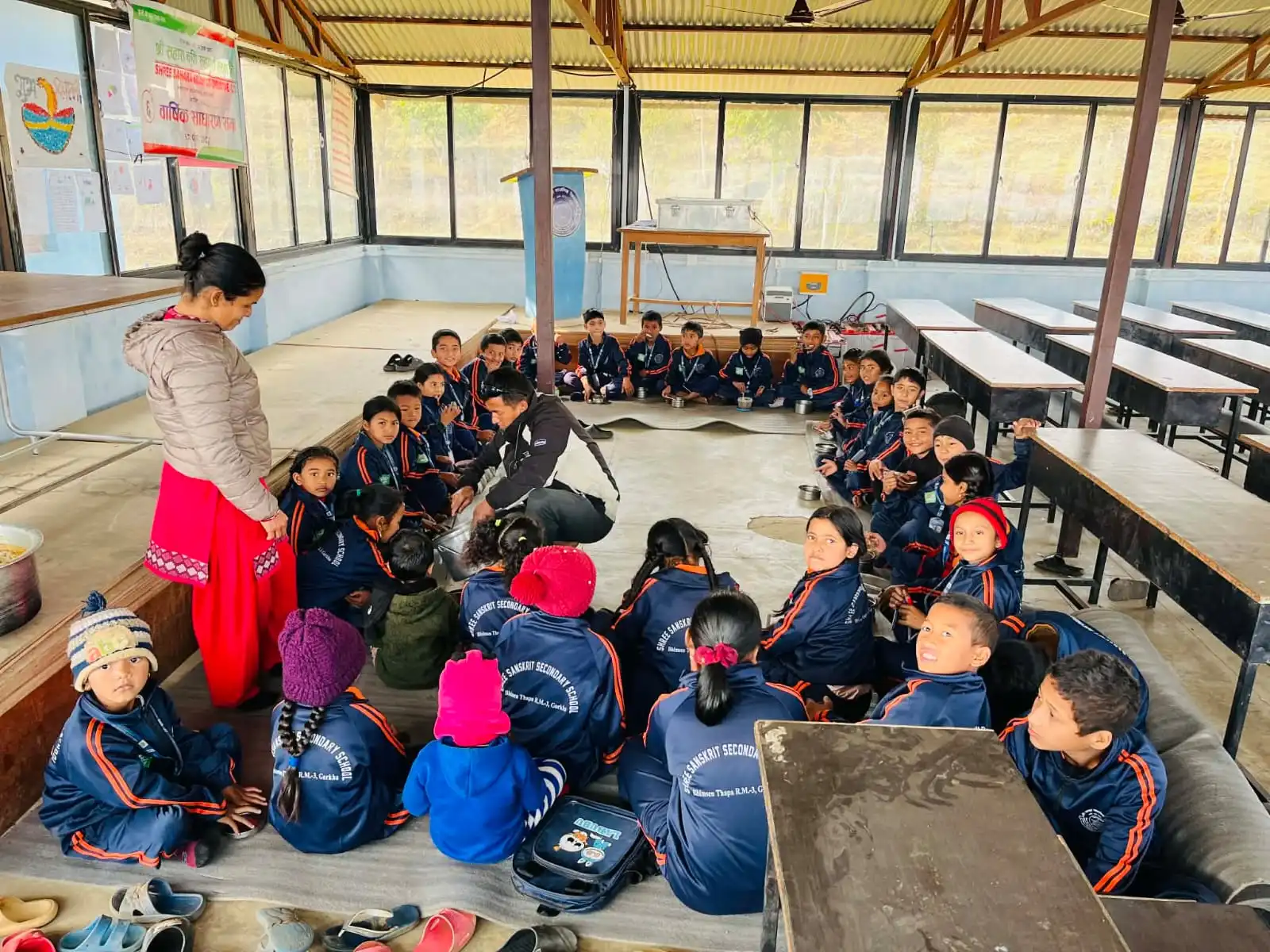 Kinderen zitten samen voor een schoolmaaltijd in Nepal.