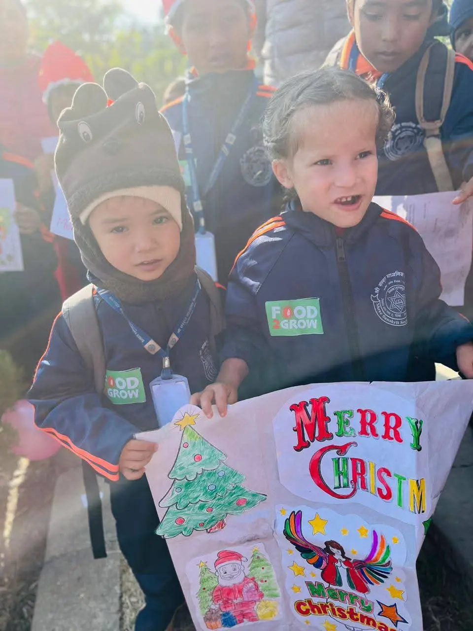 Kinderen tonen kersttekeningen tijdens een schoolactiviteit in Nepal.
