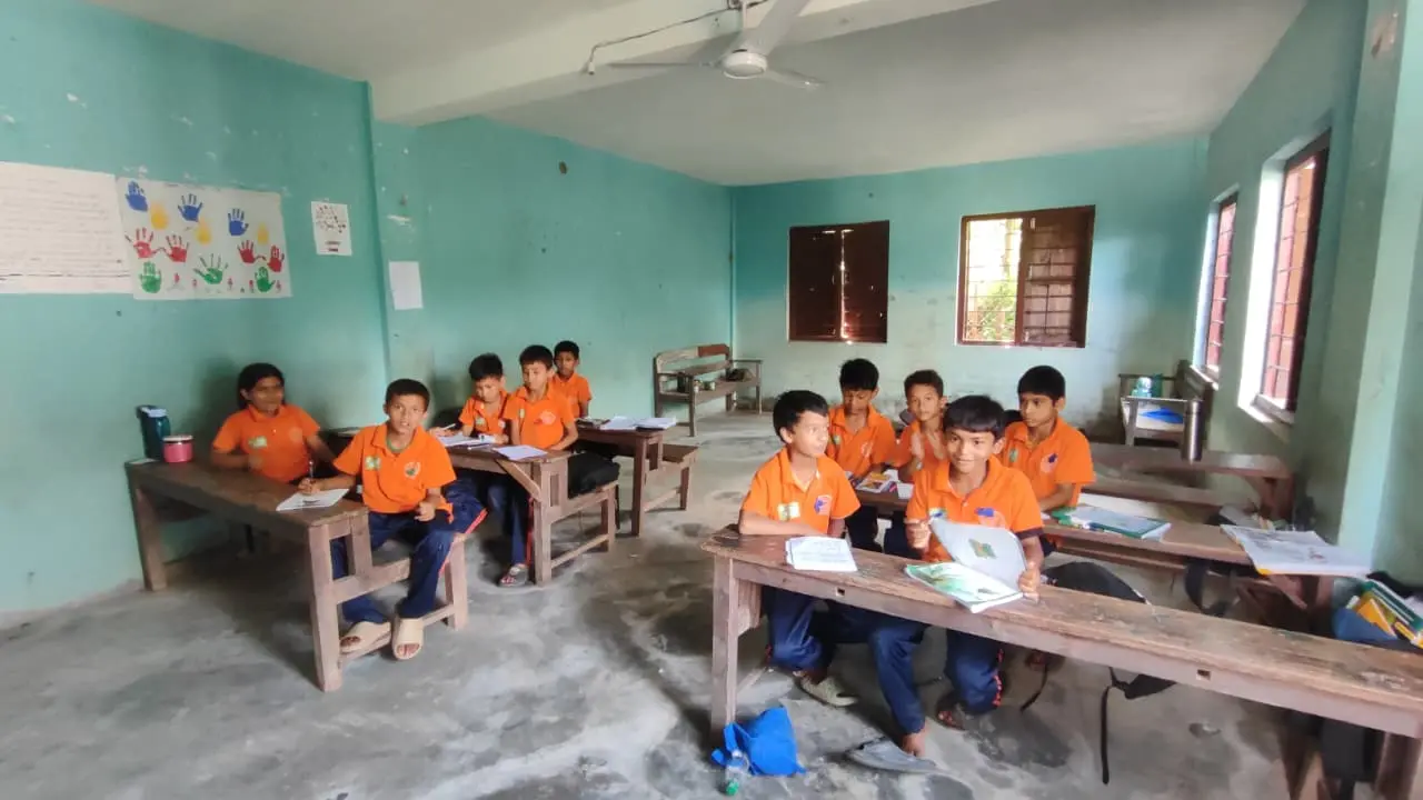Leerlingen zitten aan houten schoolbanken in een klaslokaal in Nepal.
